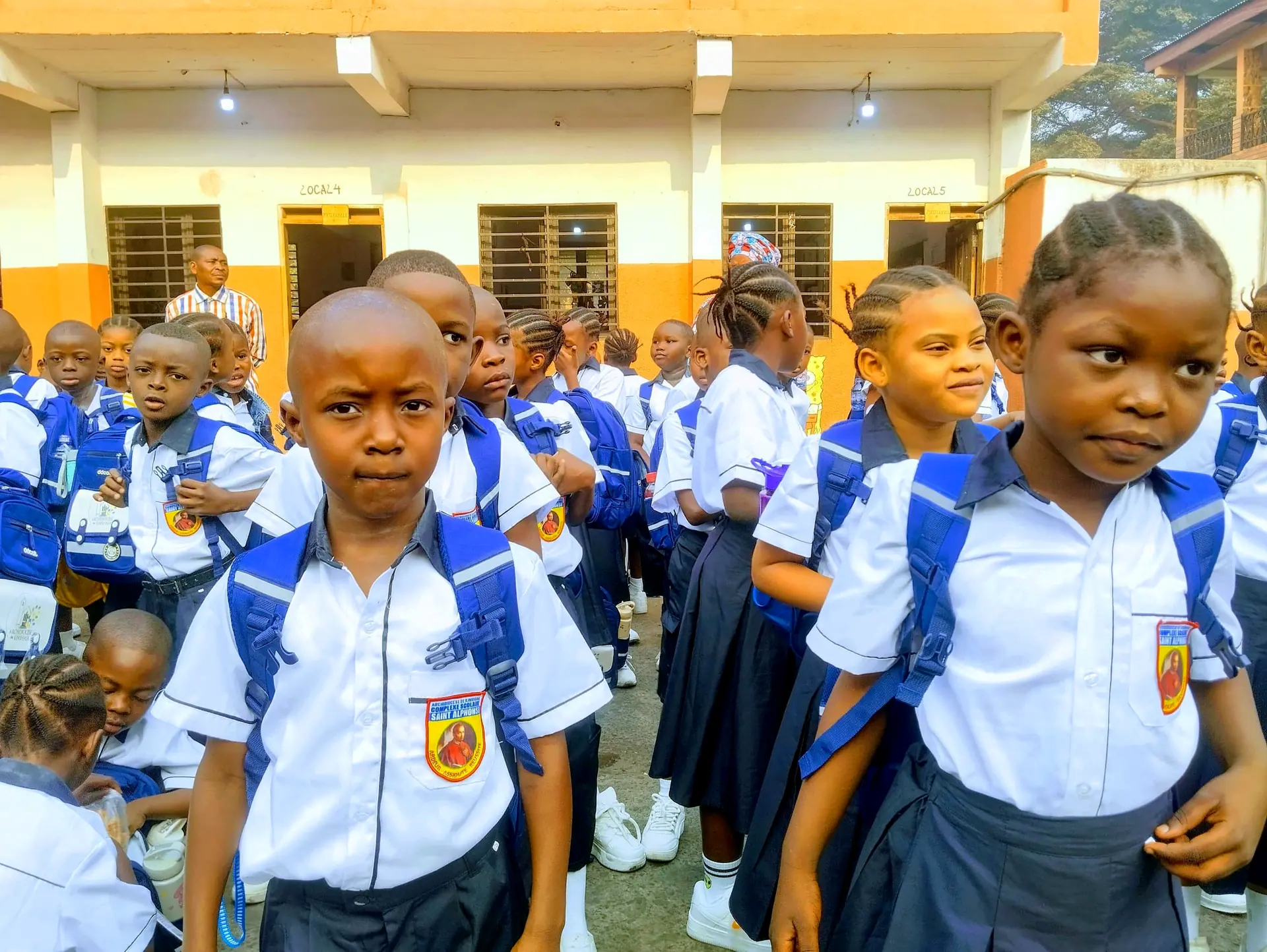 Élèves du CS Saint Alphonse en uniforme, cartable au dos, le jour de la rentrée